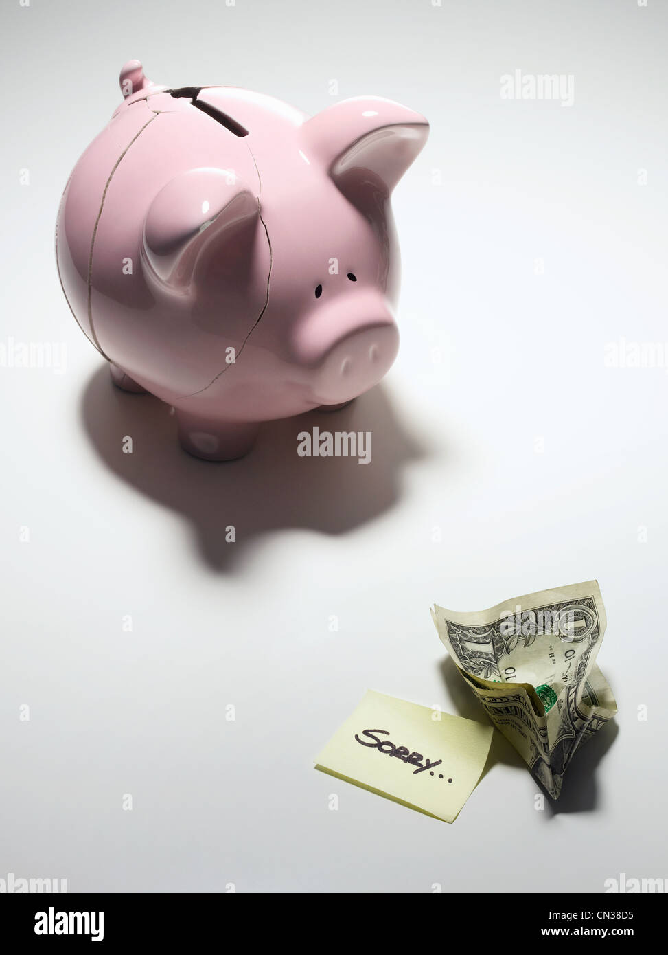 Gebrochene Sparschwein mit einem Dollarschein und sagen, sorry Stockfoto