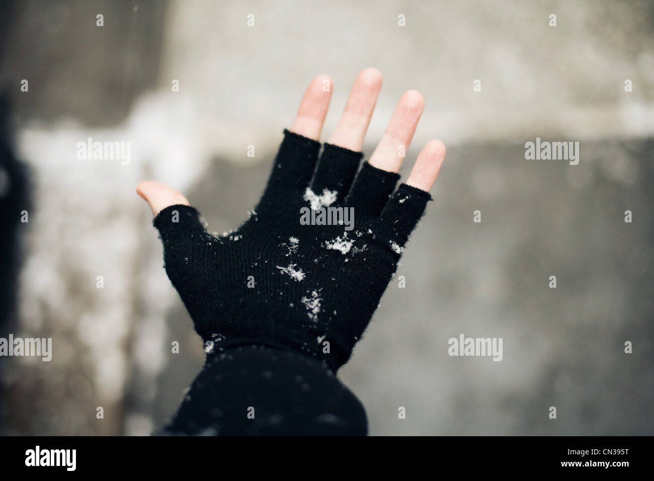 Trägers fingerlosen Handschuh im Schnee Stockfoto