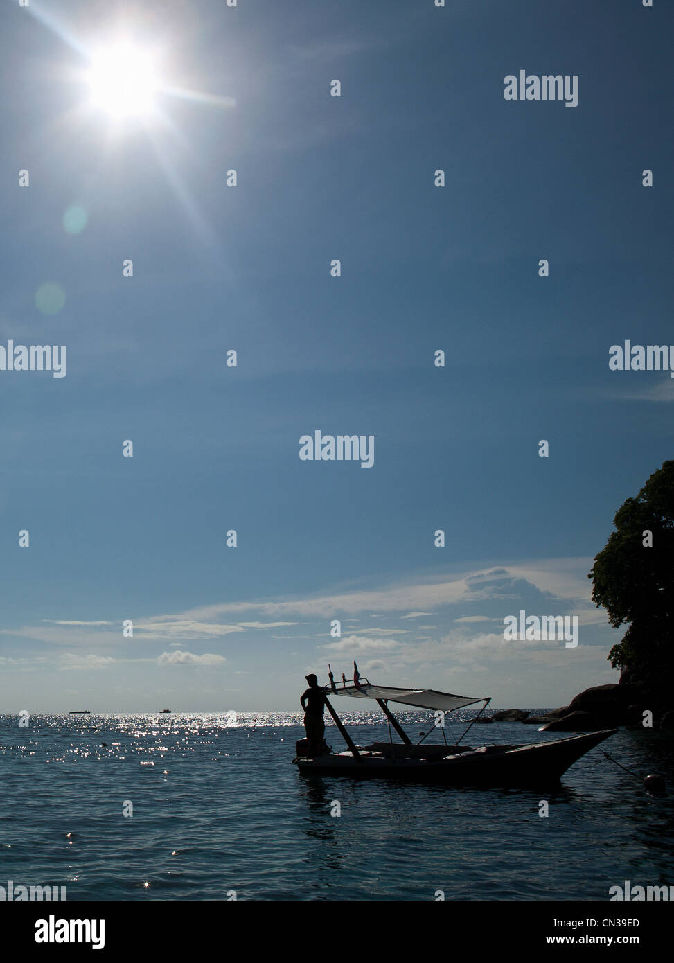 Mann auf angedockten Boot im Sonnenlicht, Tioman Island, Malaysia Stockfoto