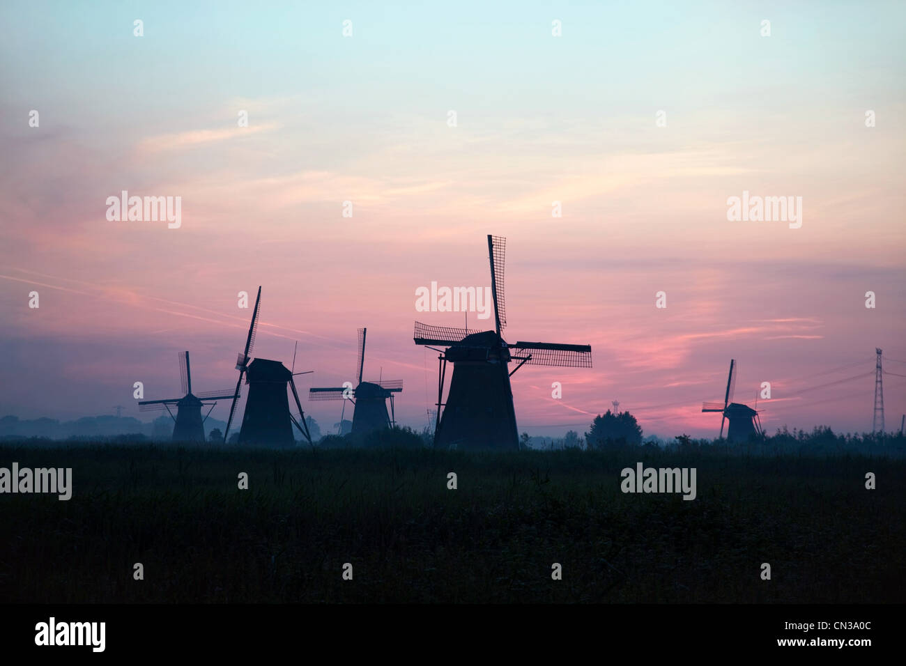 Silhouetten von Windmühlen bei Sonnenuntergang, Niederlande Stockfoto
