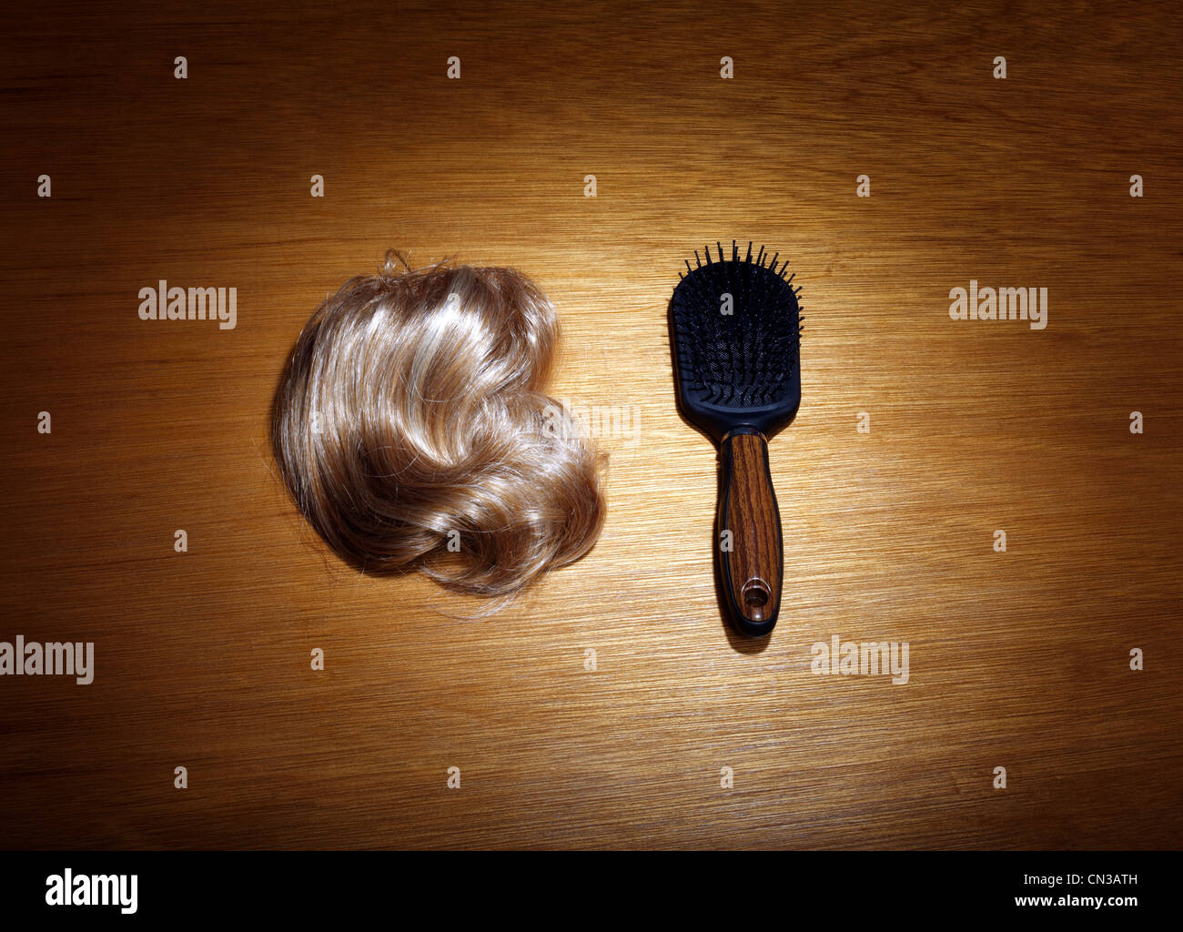 Haarteil und Haarbürste auf Holztisch Stockfoto