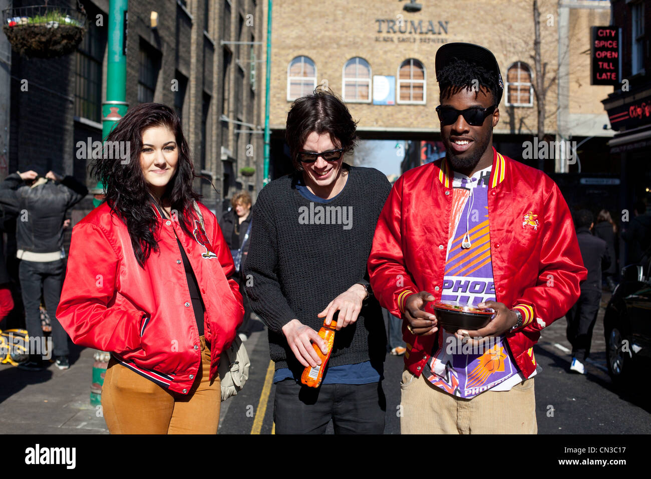 Mittelbild von drei interrassischen Freunden, Brick Lane, London, England, Großbritannien. Stockfoto