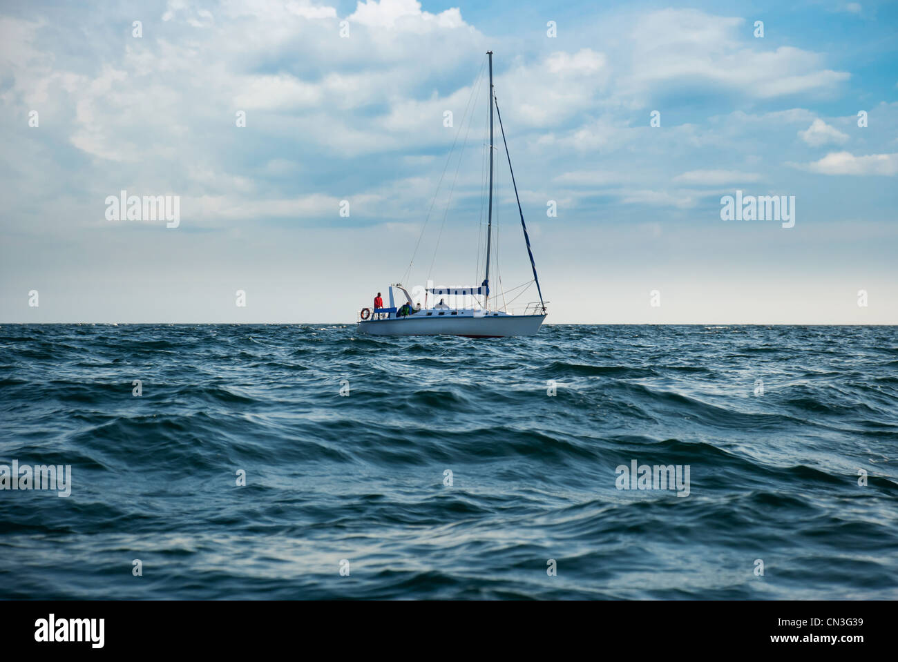 Eine Yacht in stürmischer See. Ein Boot senkte die Segel und unkenntlich Menschen Stockfoto