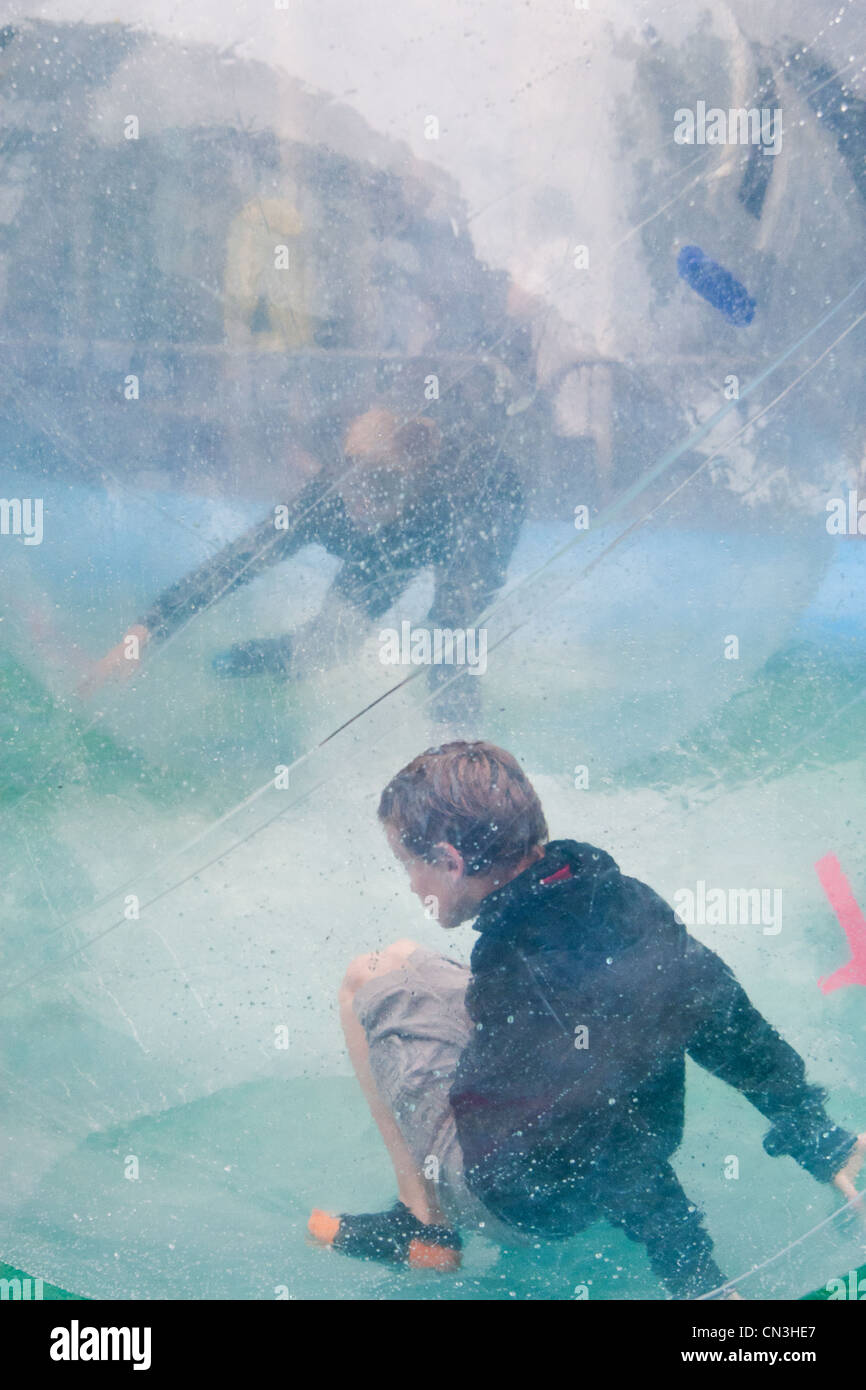 Jungs spielen in eine aufblasbare "Wasser Walker" ("Hamster Ball") Attraktion: Queen Street, Cardiff Stockfoto