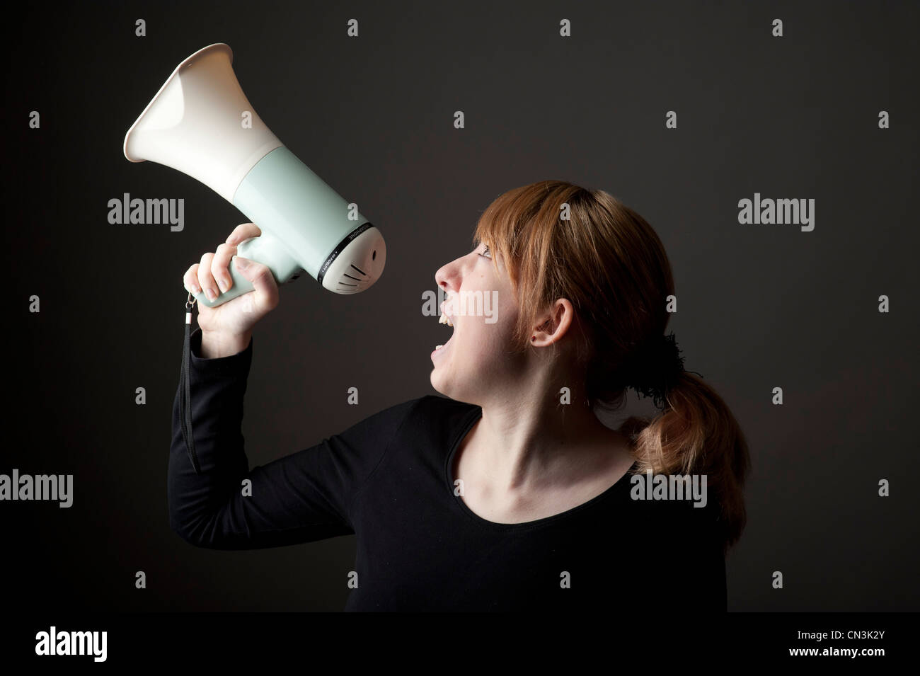 eine junge Frau Mädchen schreien durch ein Megaphon Stockfoto