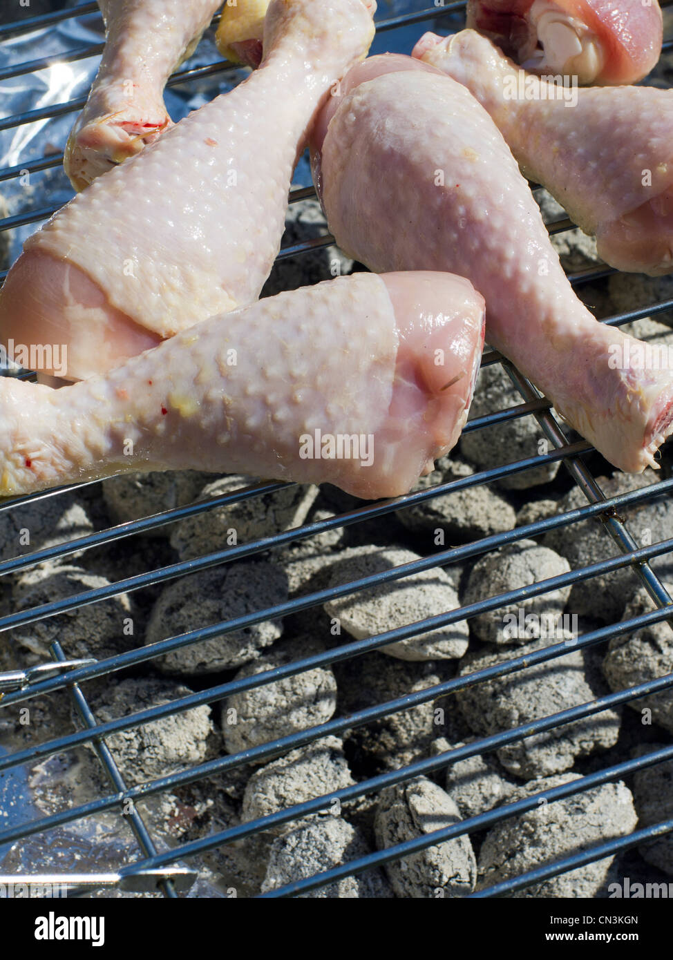Rohe ungekochte Hähnchen Drumsticks auf einem Grill. Stockfoto