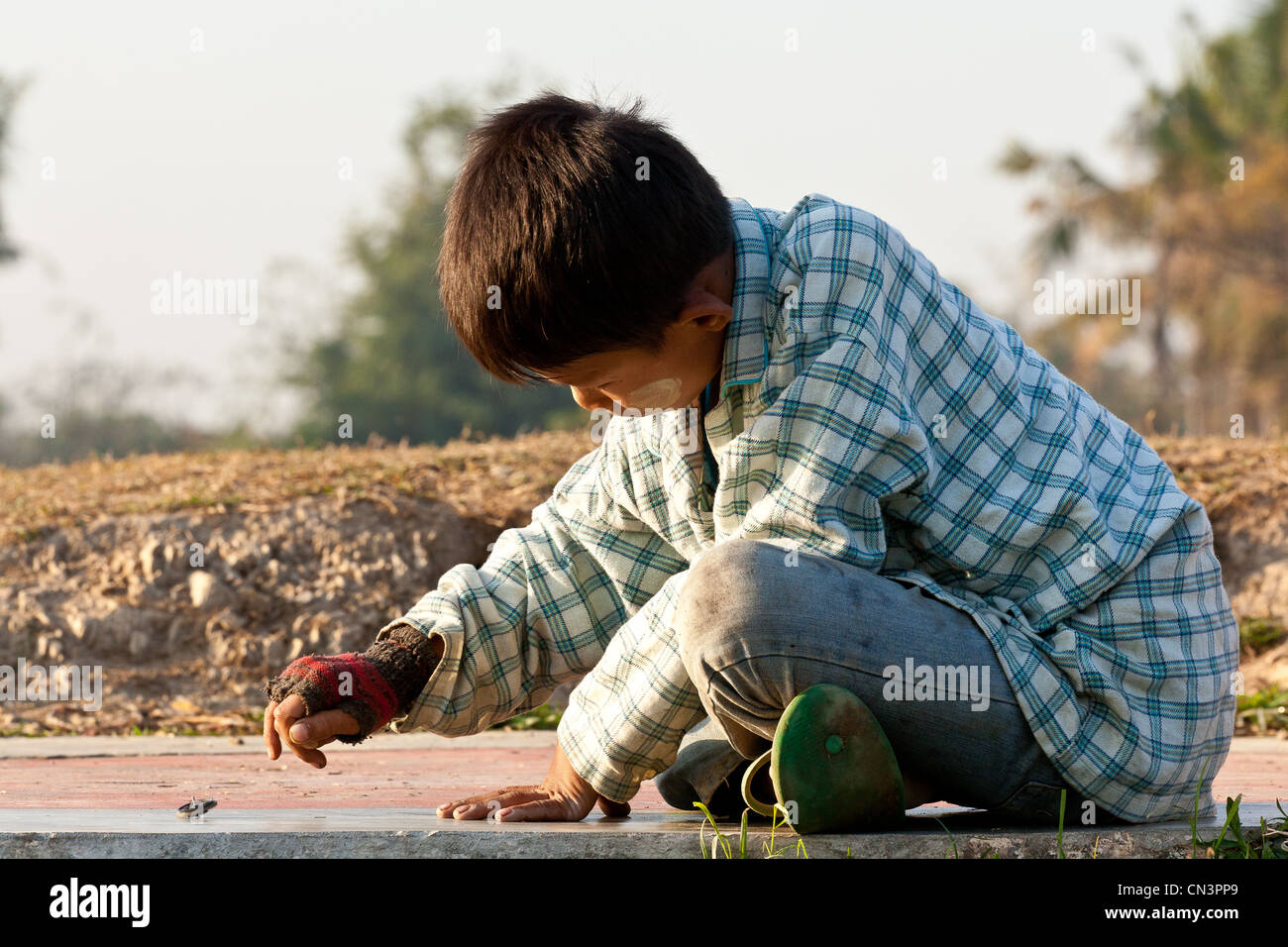 Myanmar (Burma), Rakhine (Arakan) Zustand, Mrauk U, junge spielt mit einem Kreisel Stockfoto