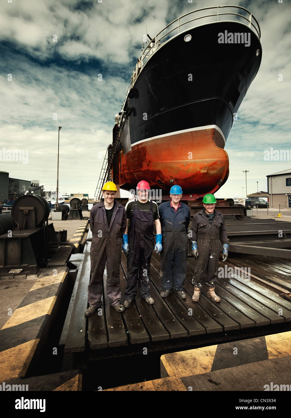 Hafenarbeiter in farbige Schutzhelme in einer Linie Stockfoto