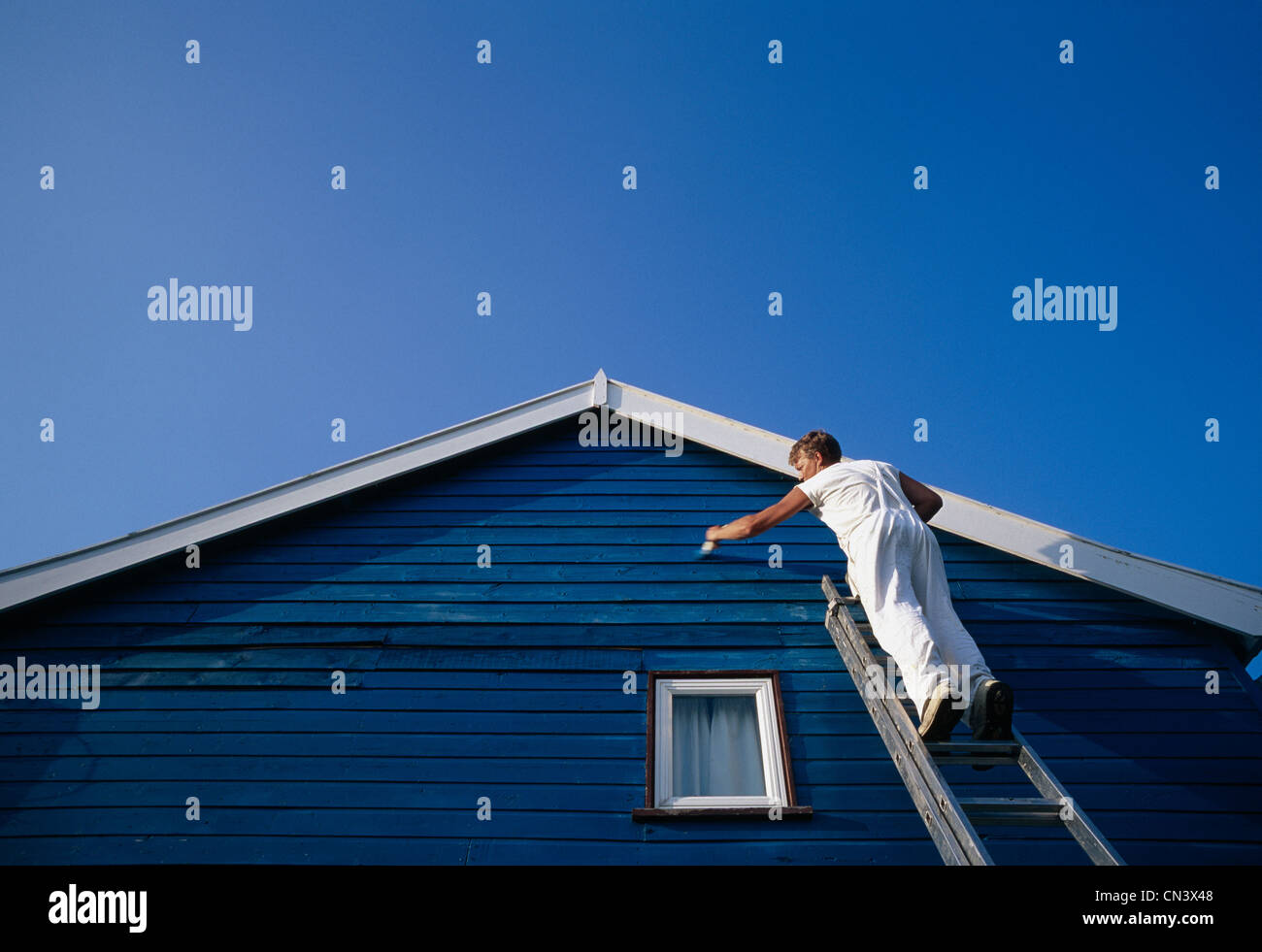 Ein Mann der abweisendem eines Hauses malen Stockfoto