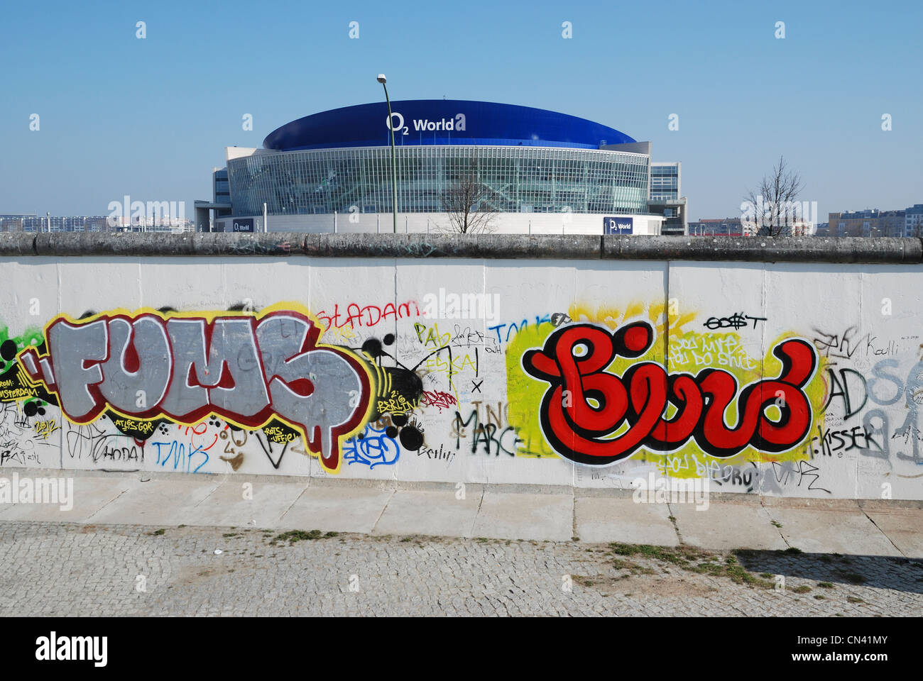 Die Graffiti bedeckt Westseite der Berliner Mauer an der East Side Gallery, mit der O2 World Arena in den Hintergrund. Stockfoto