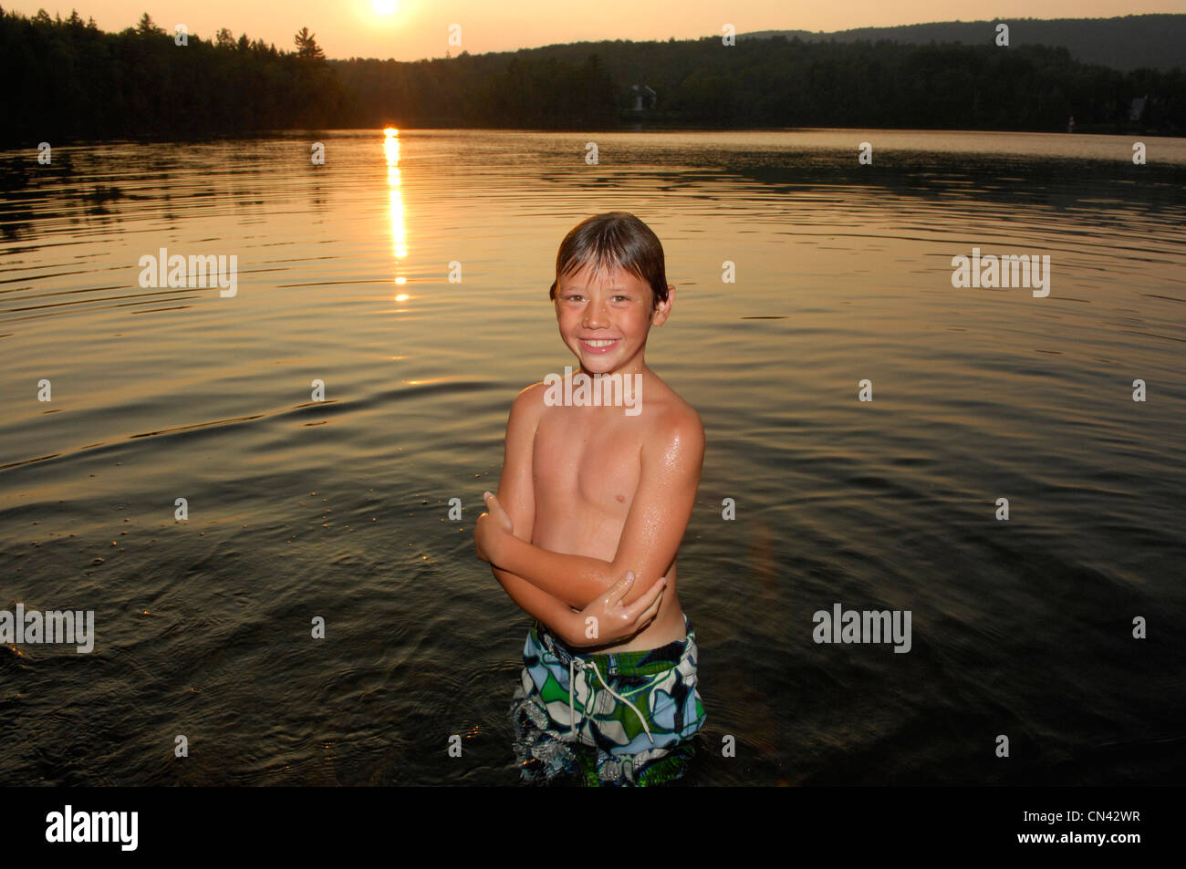 Young Boy stehen im See bei Sonnenuntergang, Lac des Neiges, Quebec Stockfoto