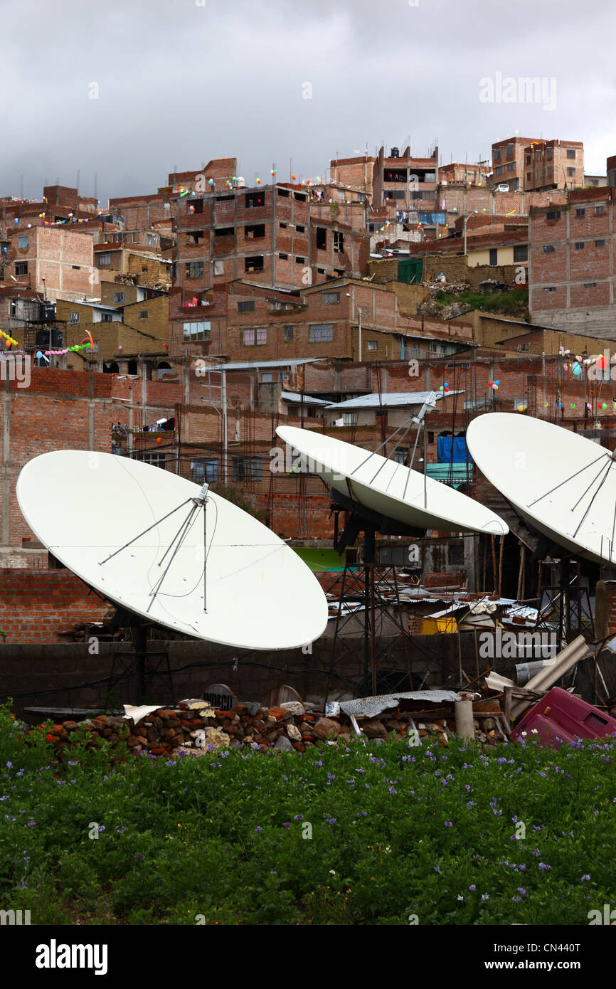 Satellitenfernsehen, Geschirr und Backsteinhäuser am Hang in den Vororten von Puno, Peru Stockfoto