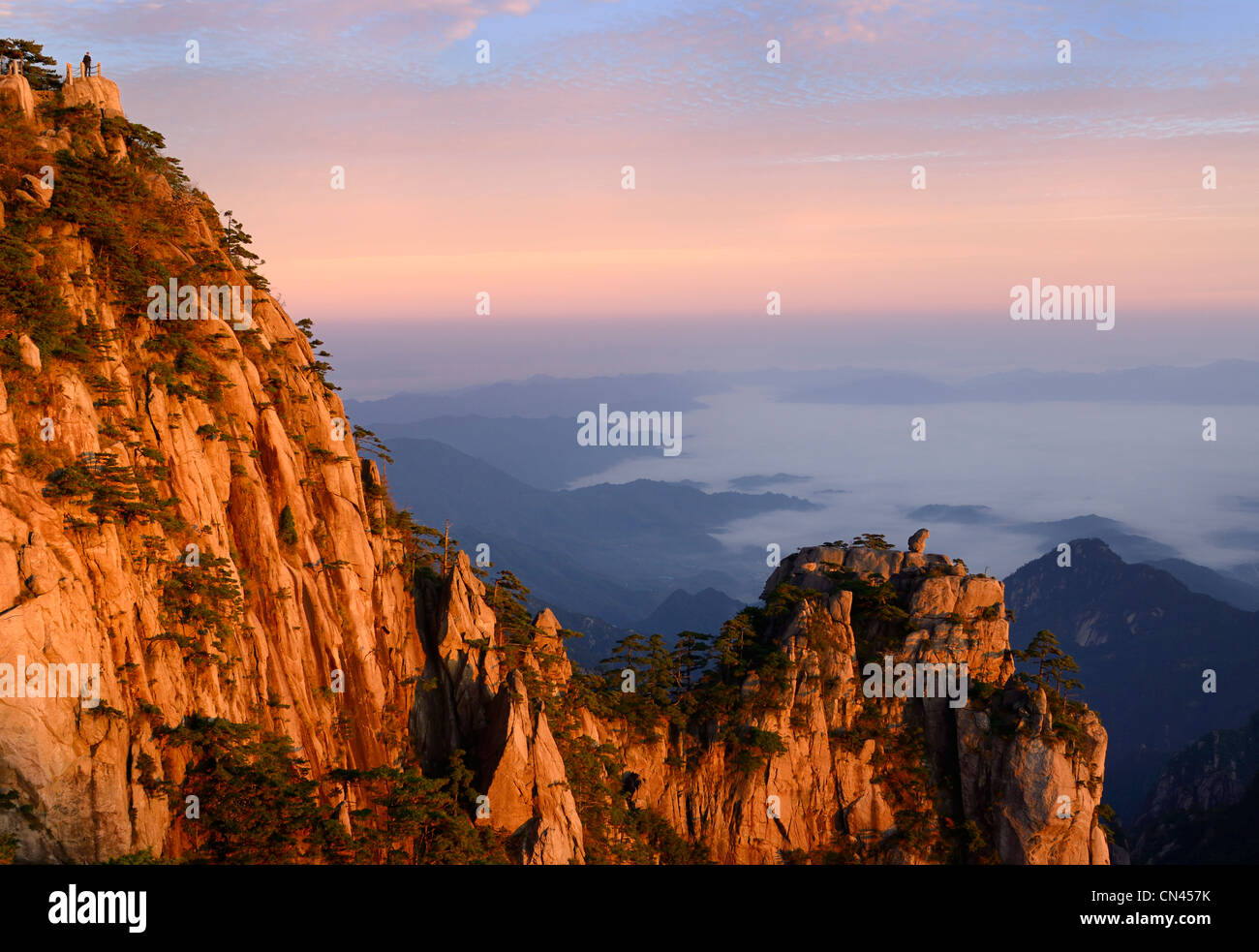 Rote Sonne auf Lion Peak und Stein Affe das Meer peak an der ersten Ampel mit Nebel im Tal von huangshan Yellow Mountain china Stockfoto