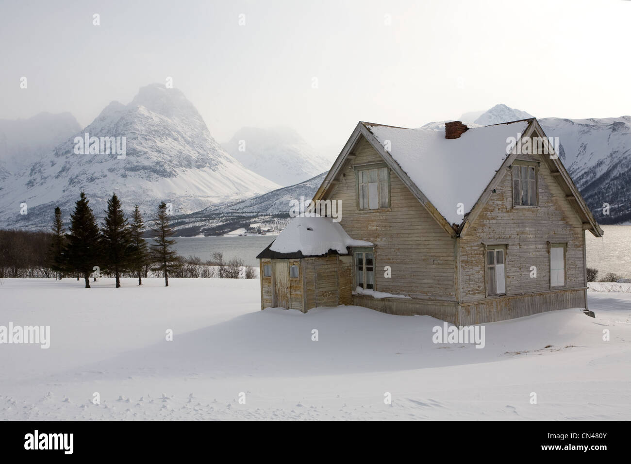 Norwegen, Troms Grafschaft, Lyngen Alpen, grau Holzhütte mit Bergen im Hintergrund in der Nähe von Svensby Stockfoto