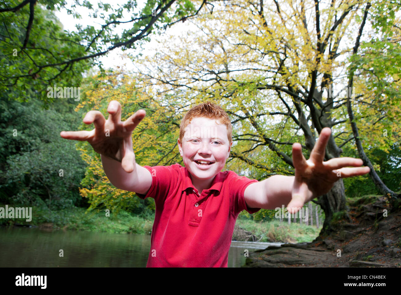 Junge, die vorgibt, ein Monster in einem Waldgebiet Stockfoto