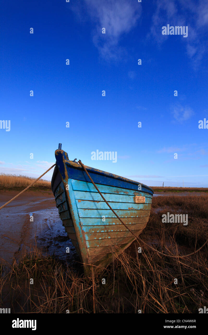 Eine blaue Holzboot und blauen Himmel bei Brancaster Staithe an der North Norfolk-Küste. Stockfoto