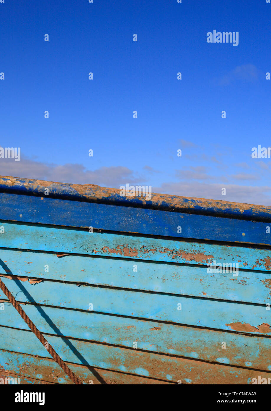 Eine blaue Holzboot und blauen Himmel bei Brancaster Staithe an der North Norfolk-Küste. Stockfoto