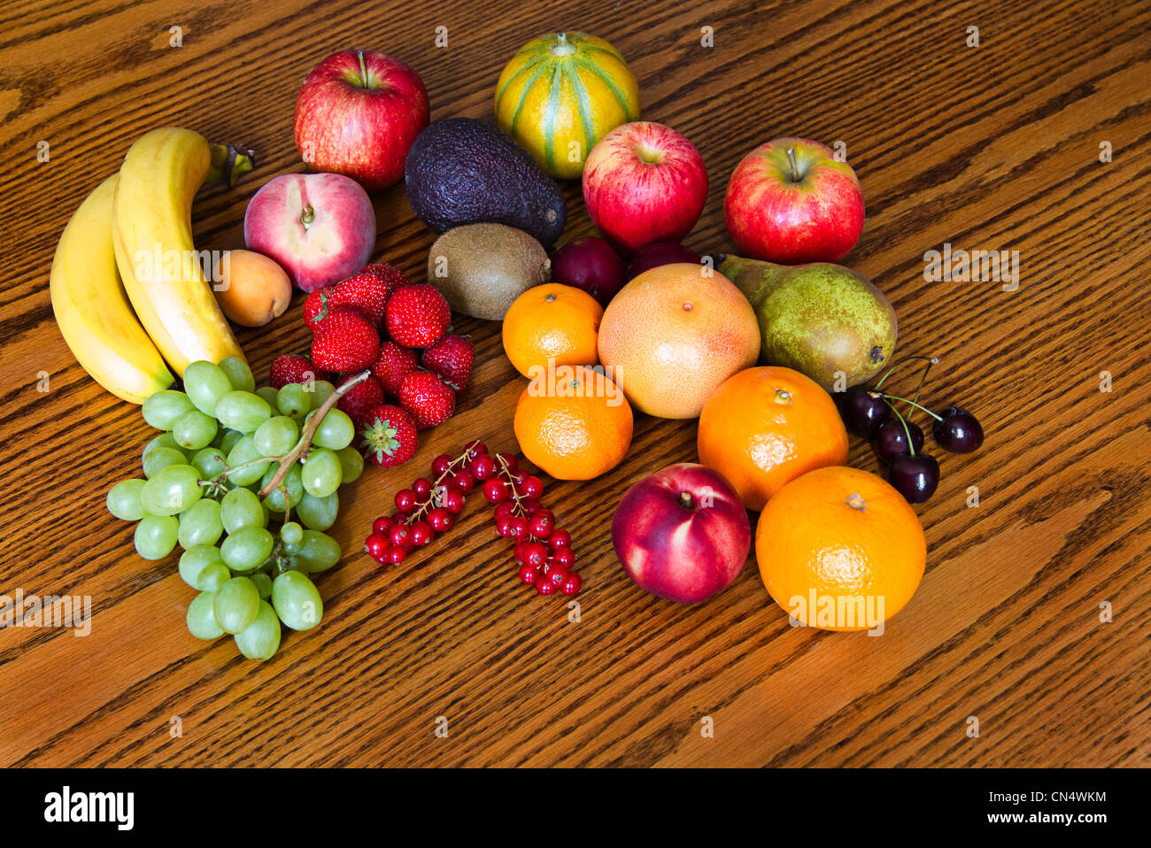 Auswahl an bunten, frischen, natürlichen aussehenden Früchten auf hölzernen Hintergrund. Stockfoto