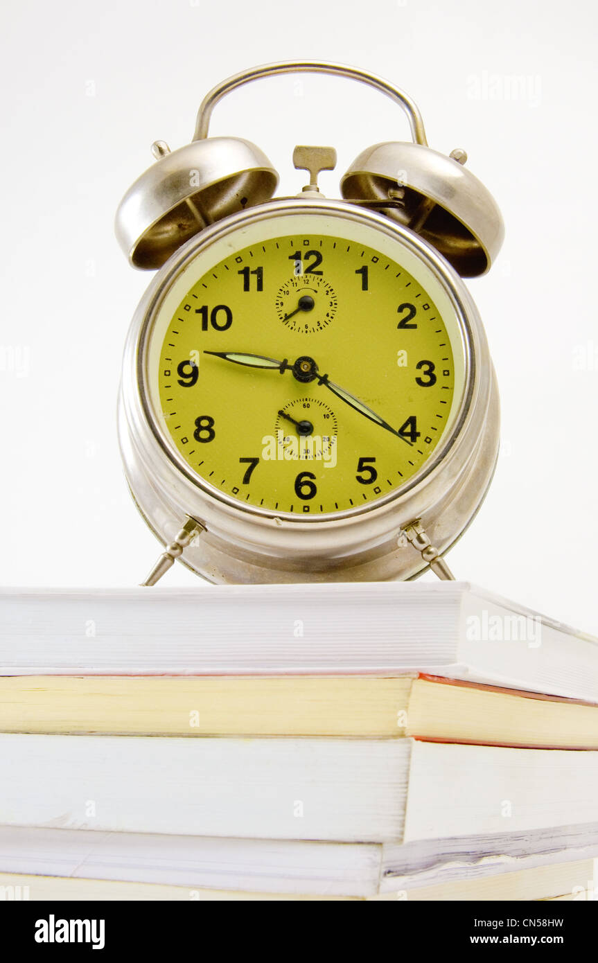 Alte, Vintage Uhr auf der Oberseite der Bücher, ist über einen weißen Hintergrund Bild aufgenommen. Stockfoto