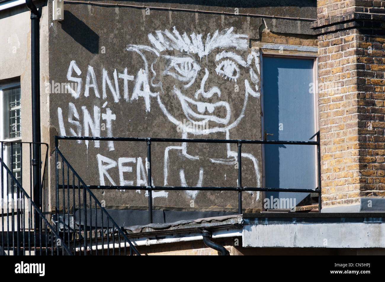 "Santa ist nicht real" Graffiti auf der Rückwand des Gebäudes gemalt. Stockfoto