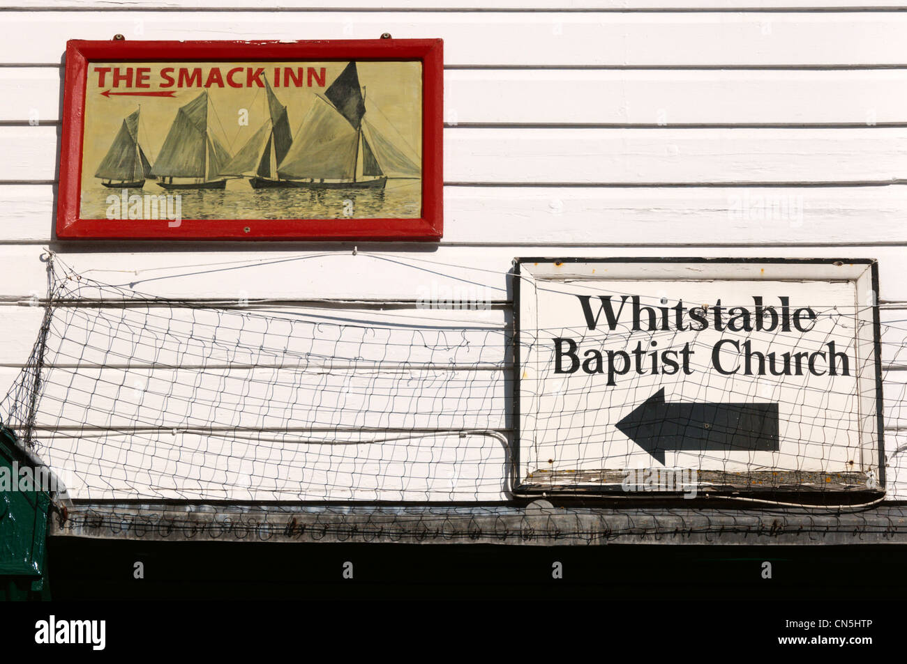 Anzeichen für The Smack Inn und Baptist Church an einem Gebäude in Whitstable High Street, Kent. Stockfoto