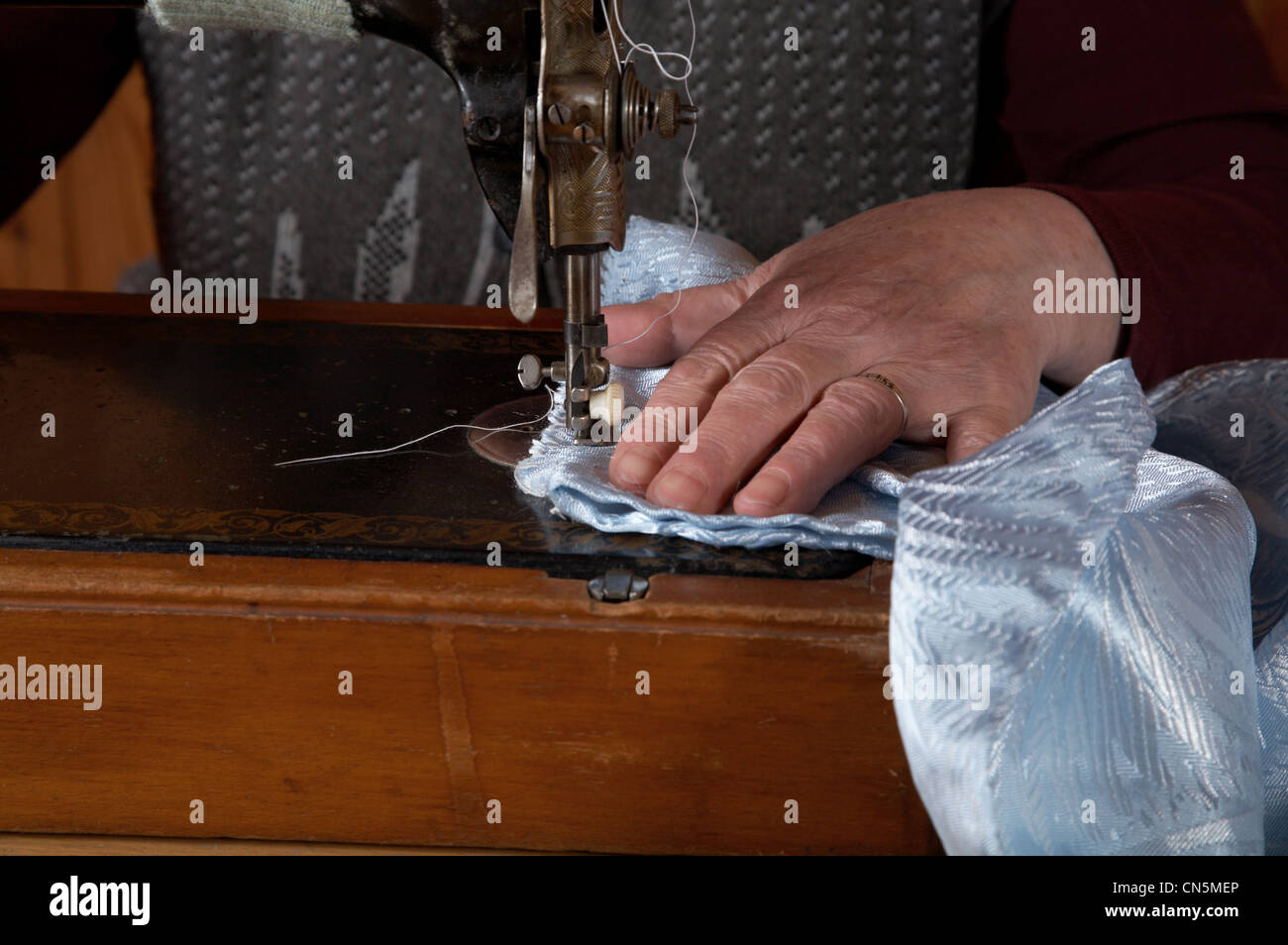 Die alte Frau näht an der Nähmaschine Stockfoto