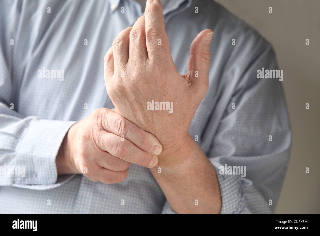 Geschäftsmann prüft die Schmerzen im Handgelenk Stockfoto