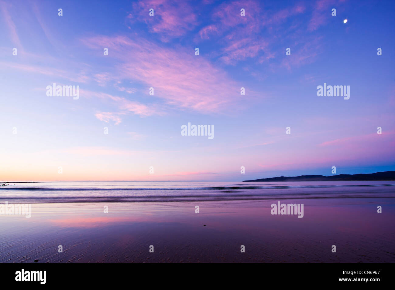 Einbruch der Dunkelheit Farben und Reflexionen am Strand nach Sonnenuntergang Stockfoto