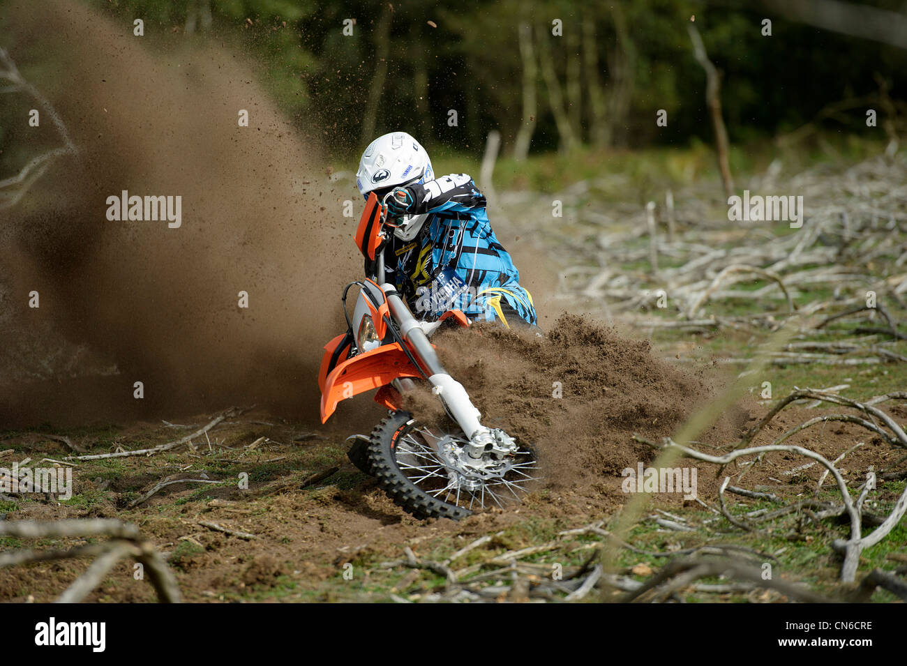 Racer Motocrossfahrer Ecke werfen viel Schlafplatz und Schmutz in der Luft hinter dem Motorrad herumfahren Stockfoto