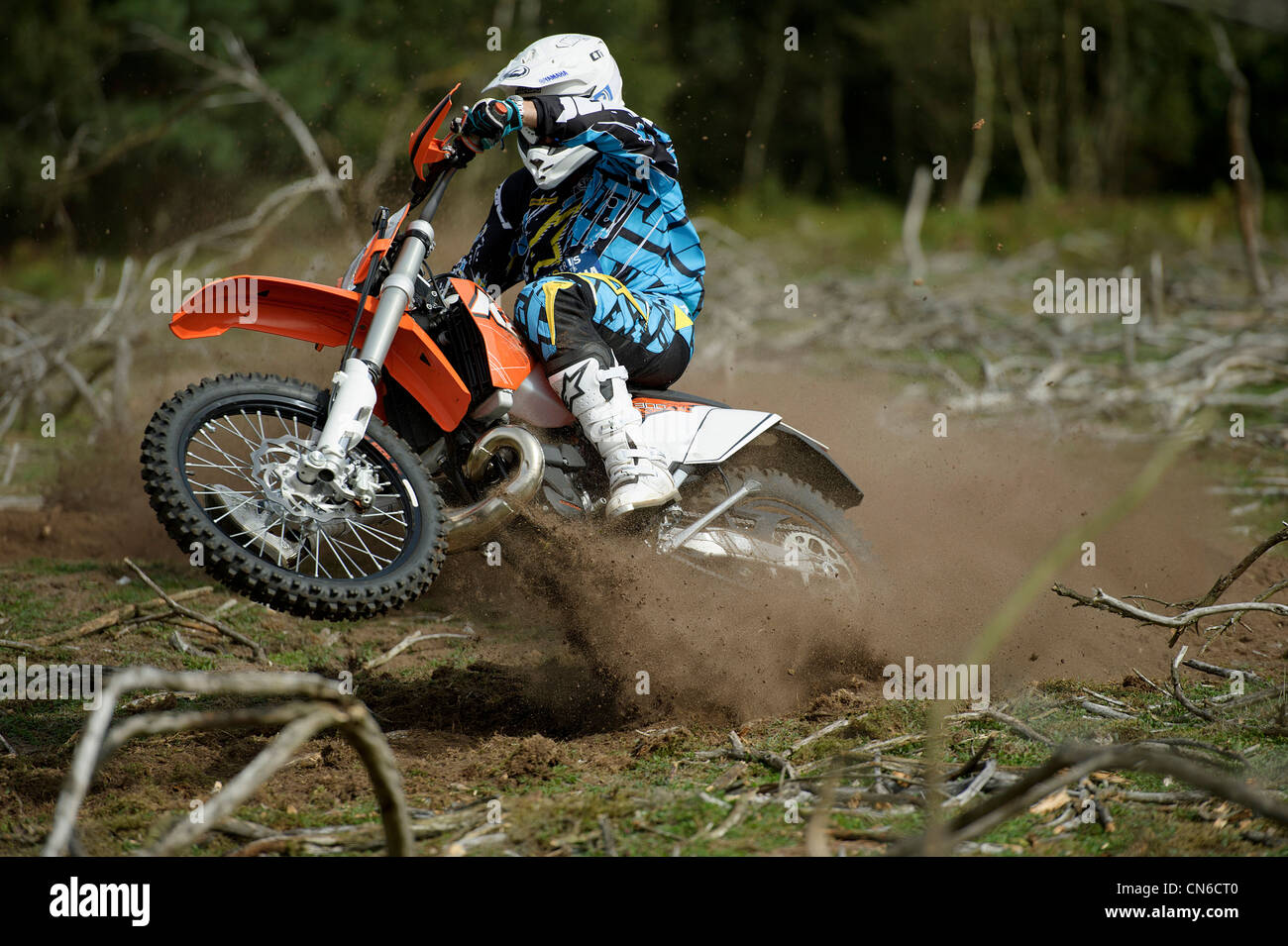 Racer Motocrossfahrer Ecke werfen viel Schlafplatz und Schmutz in der Luft hinter dem Motorrad herumfahren Stockfoto