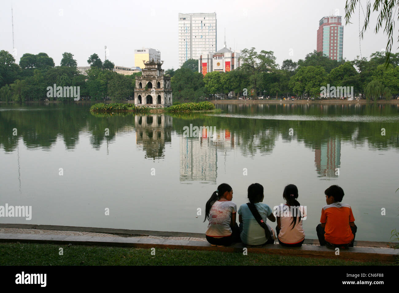 Schule Kinder sitzen auf einem See in Hanoi. Vietnam Stockfoto