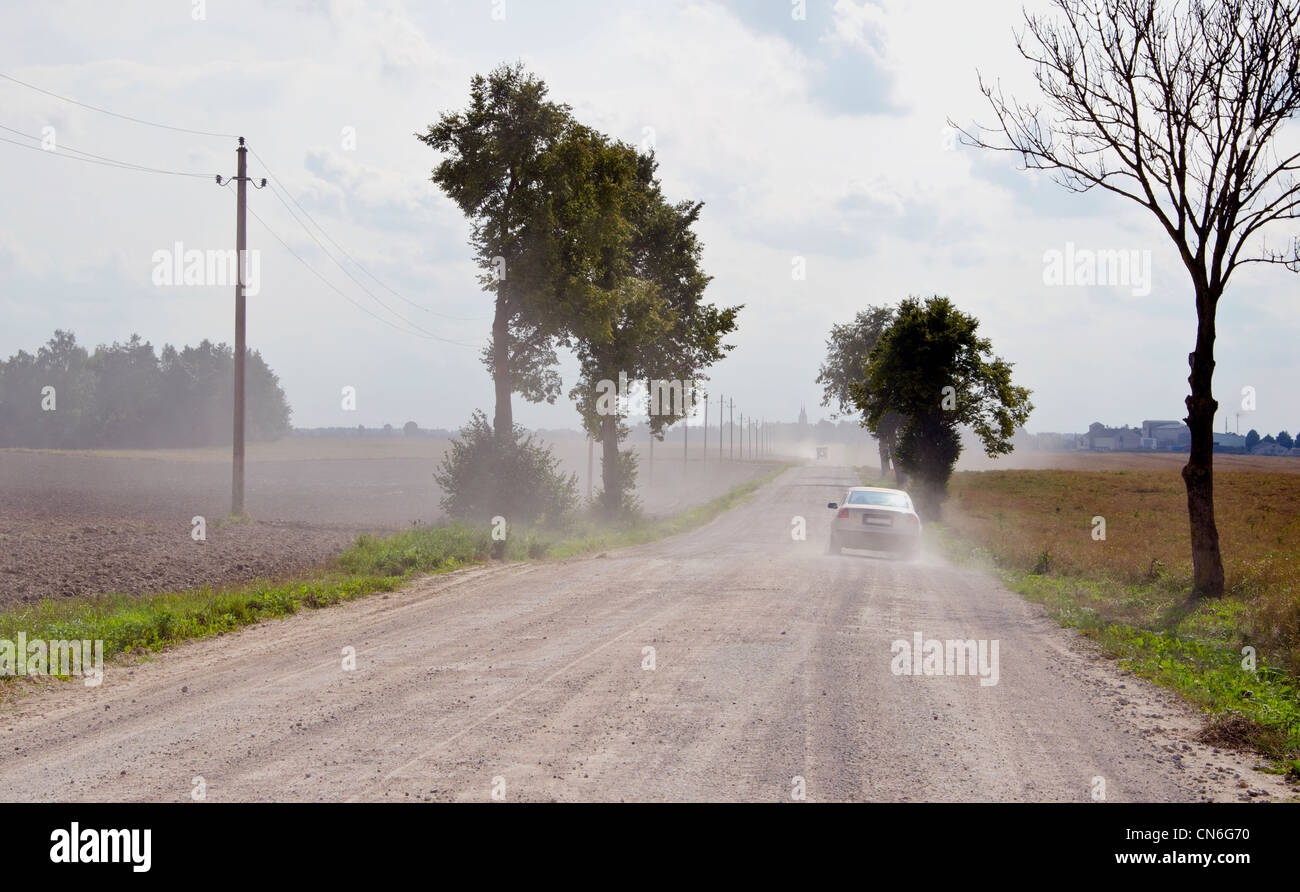 Staubige ländlichen Schotterstraße zwischen Äckern und die Maschine in Gang. Stockfoto