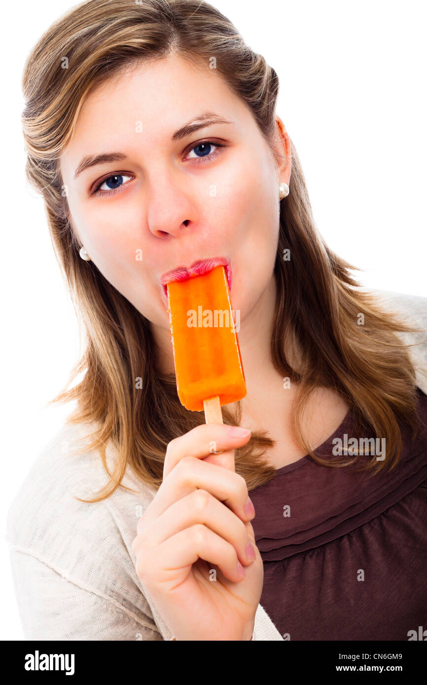 Junge schöne Frau Essen orange Eis am Stiel, isoliert auf weißem Hintergrund. Stockfoto