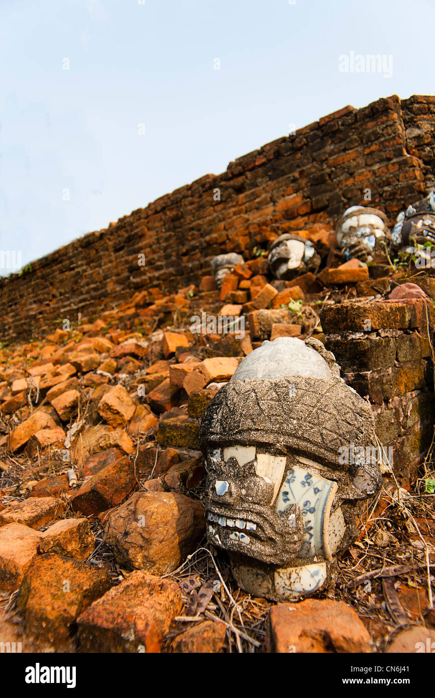 Maske auf Wand aus rotem Backstein Moos ein sehr altes Gebäude Stockfoto