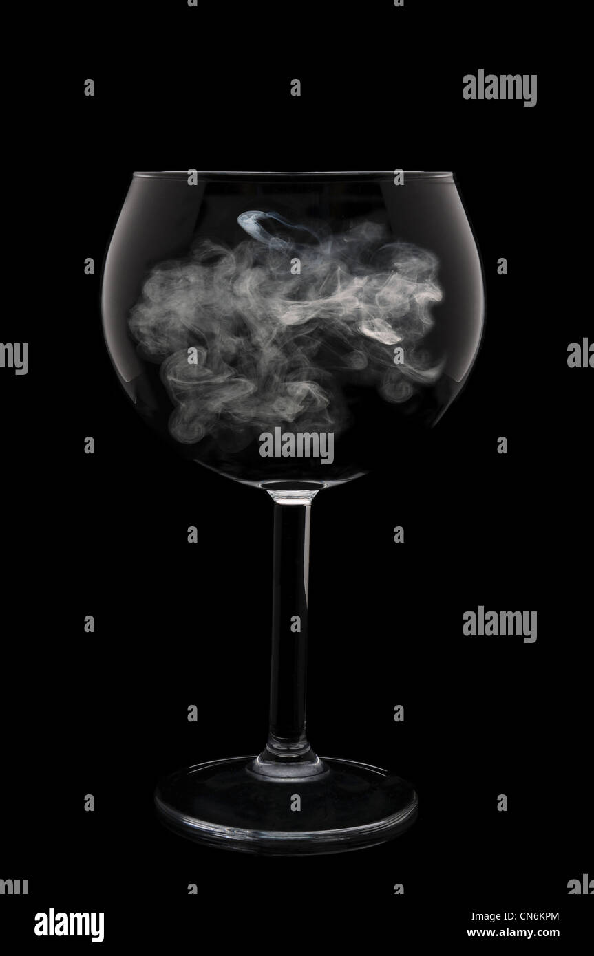 Ein Glas Wein mit einem Hauch von Rauch in die Schüssel über einen schwarzen Hintergrund. Stockfoto