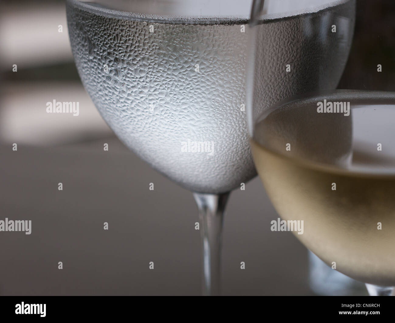 Wasser- und Weinglas abstrakt mit dem Tau-Muster von Wasserglas im Fokus. Stockfoto
