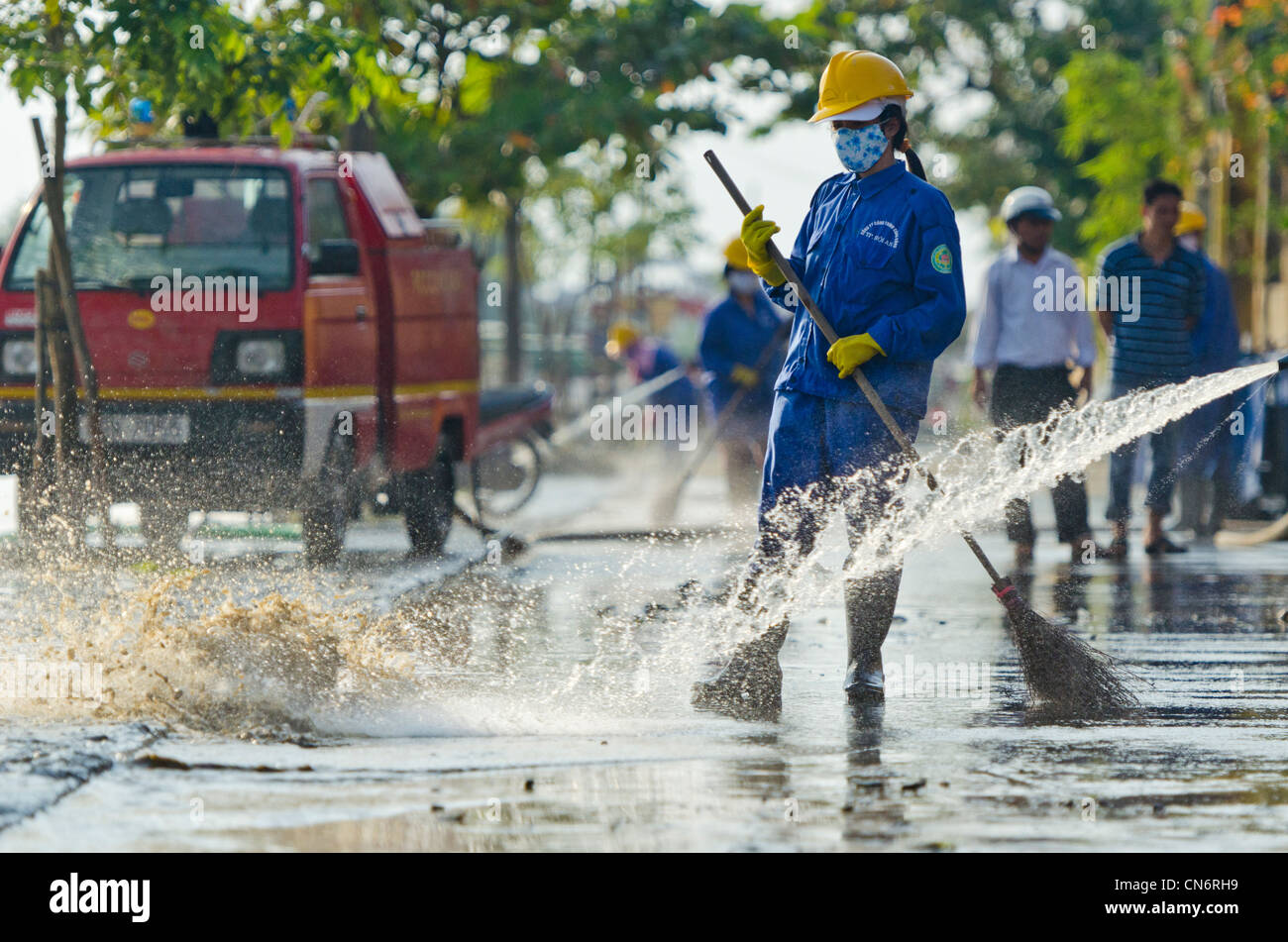 Clean-Up mit Besen und sauberes Wasser nach Überschwemmungen in Hoi an, Vietnam Stockfoto