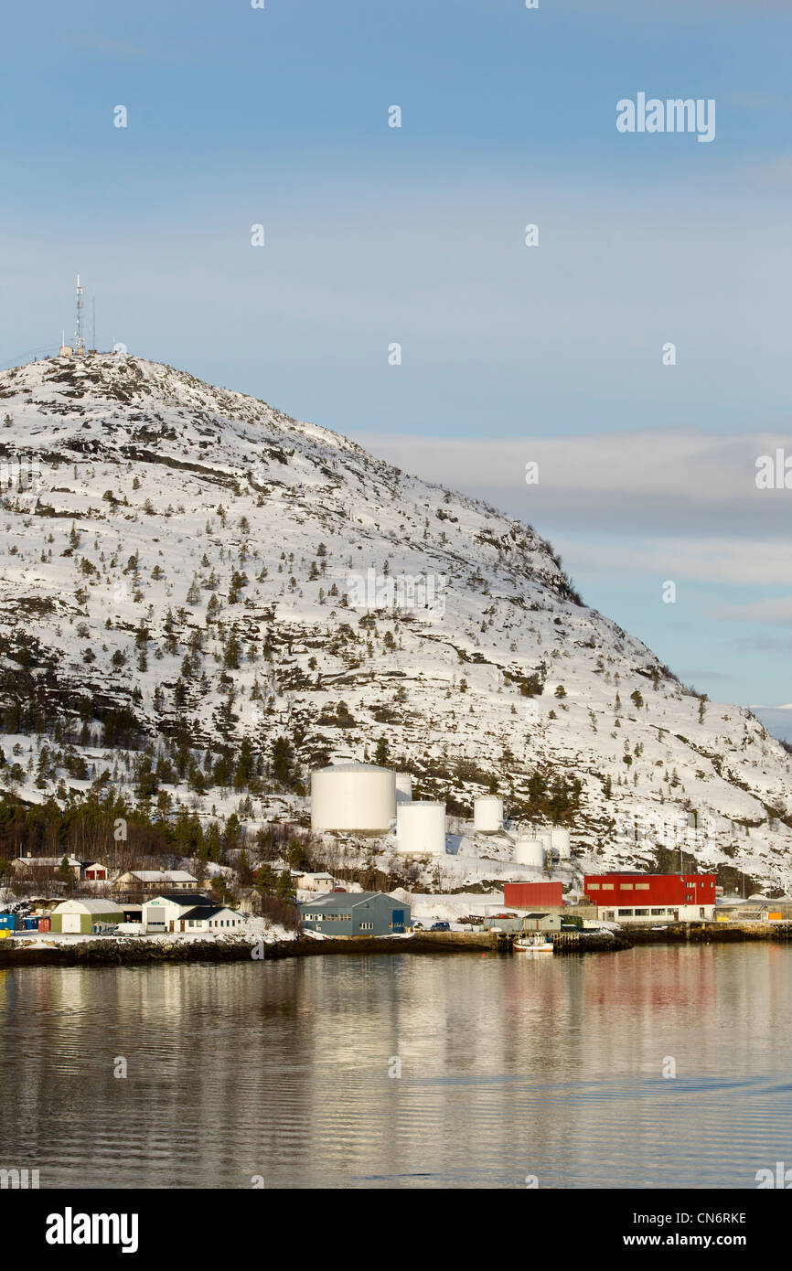 Ein Öl-Lager am Ufer an einem Fjord mit Schnee bedeckt Berg hinten genommen im Hochformat Stockfoto