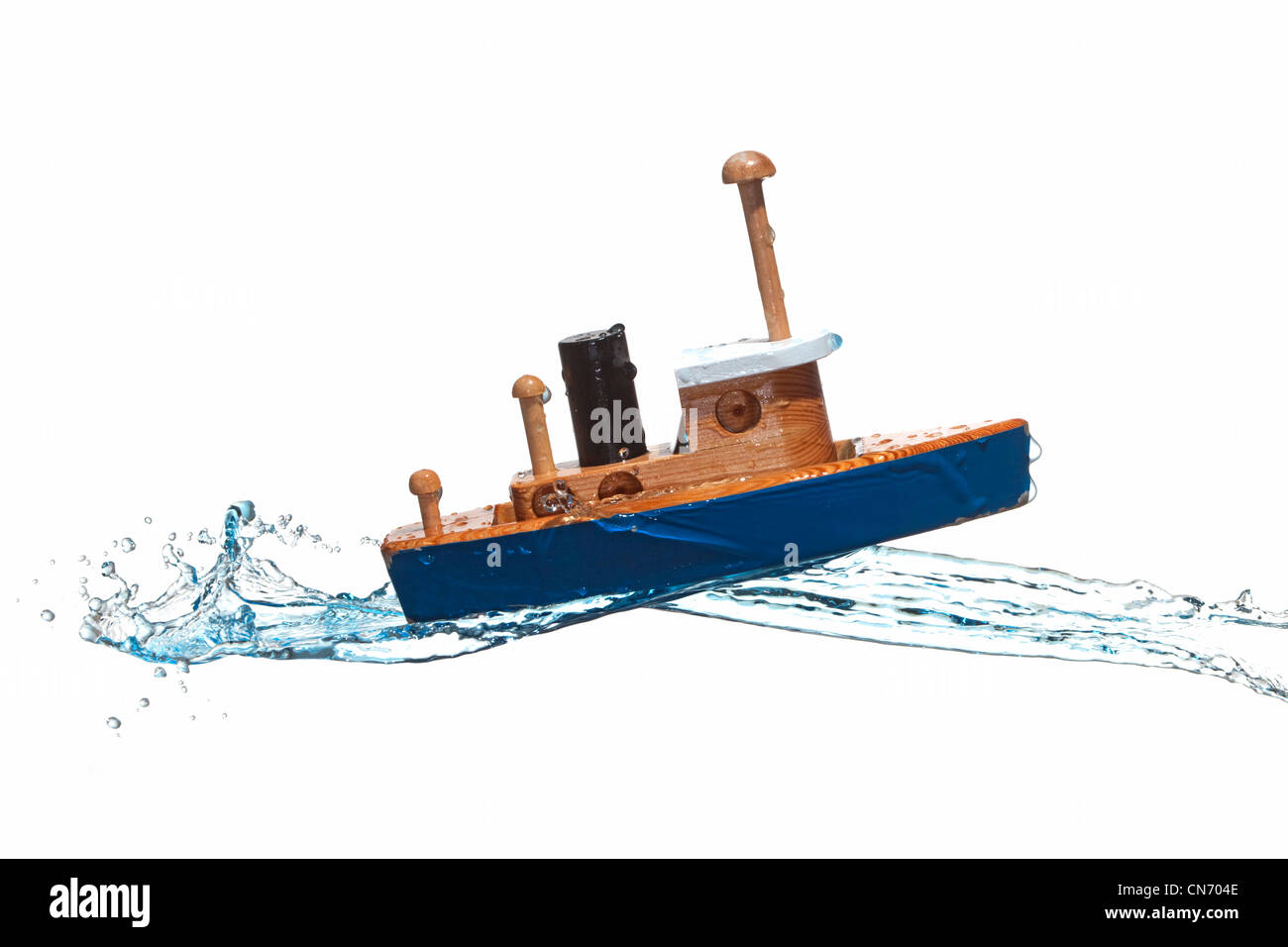 Spielzeugboot spritzte mit blauem Wasser Stockfoto
