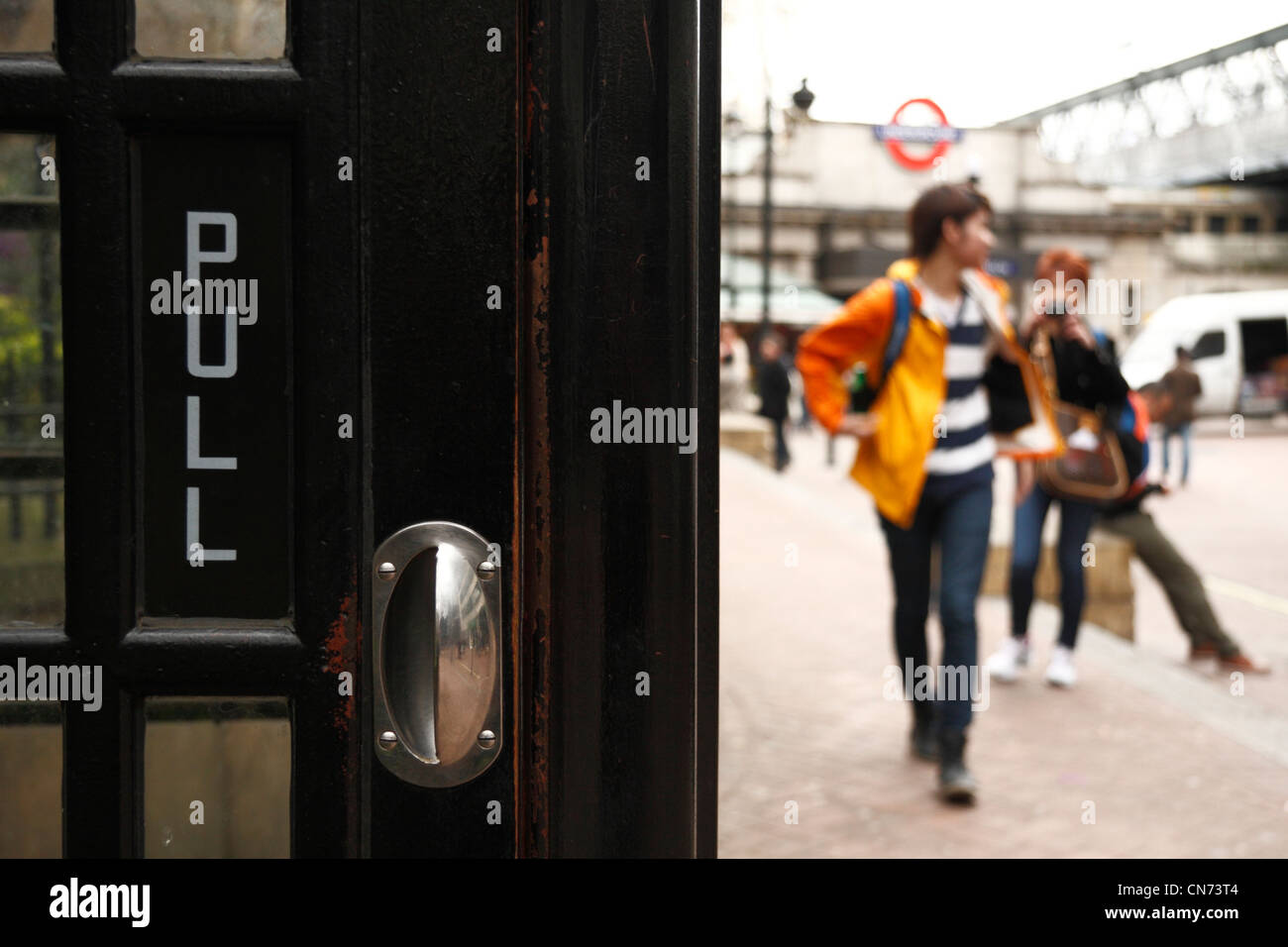 Touristen posieren für Fotos in der Nähe eines schwarzen Londoner Telefonzelle. Stockfoto