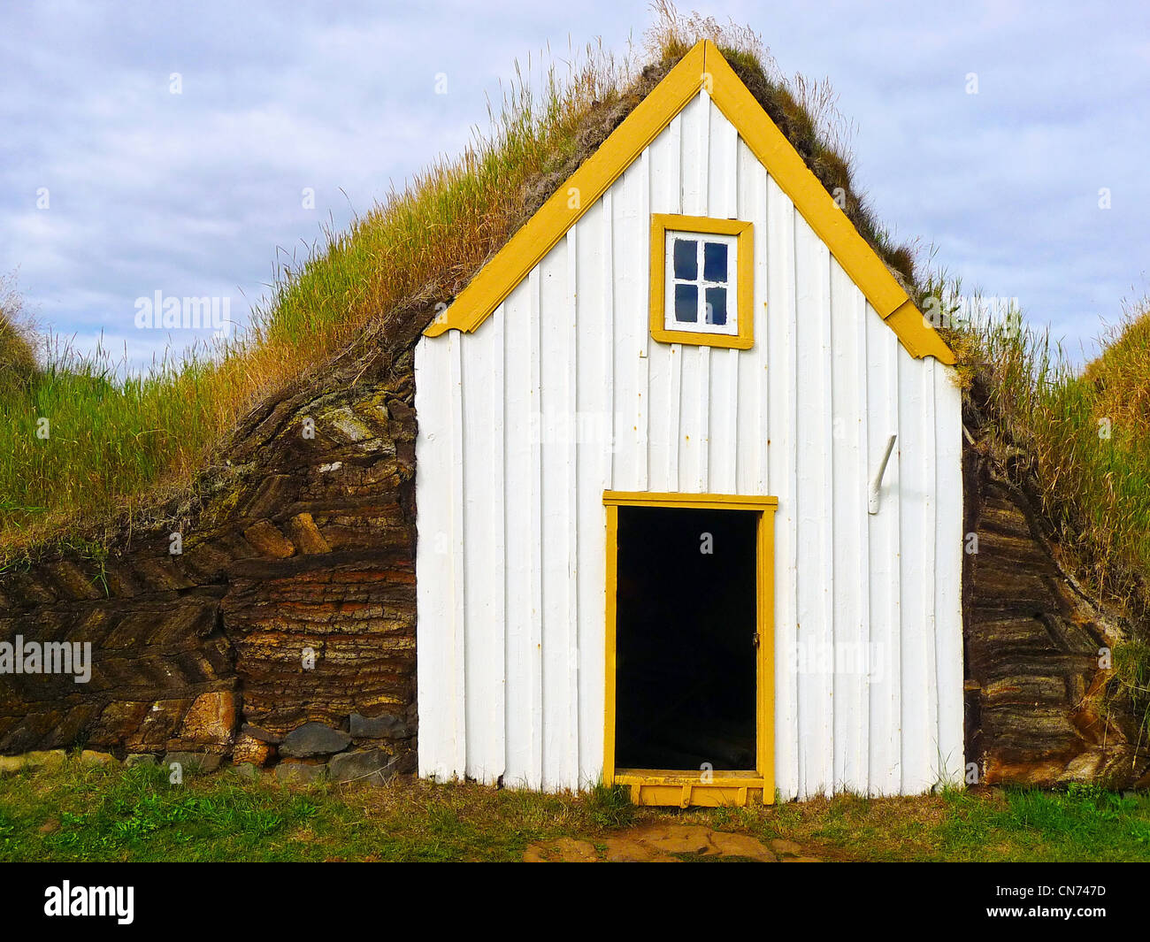 Traditionell gelb Island begrünt Dach Haus mit grünen Rasen Stockfoto