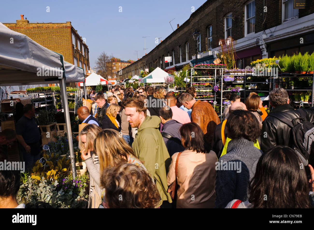 Menschen, die langsam zu Fuß durch sehr belebten Sonntag Columbia Road Flower Market, East London, UK Stockfoto