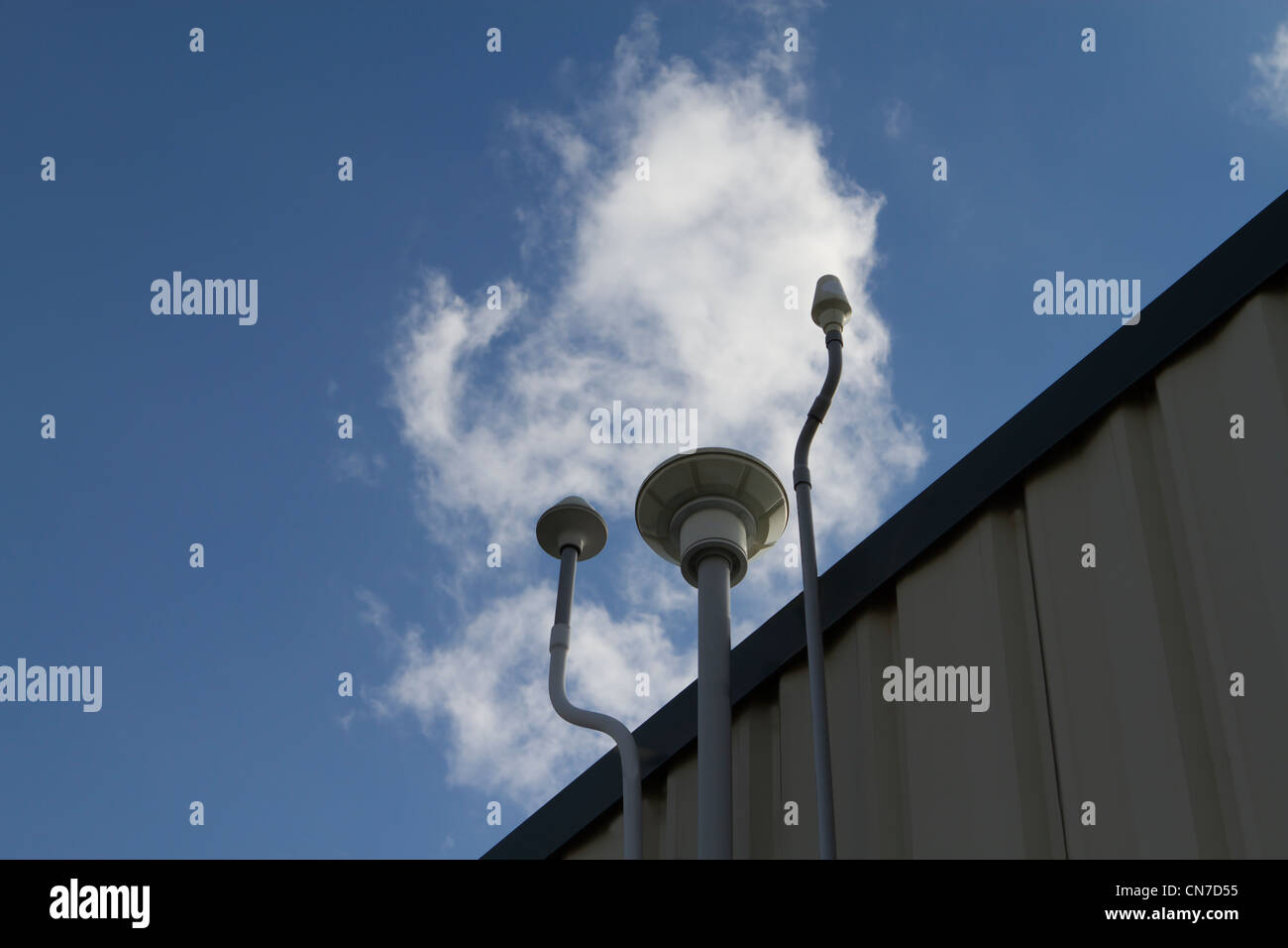 Drei verschiedene Arten von GPS-Antennen, Kompliment an den Wolken am Rande des Gebäudes. Stockfoto