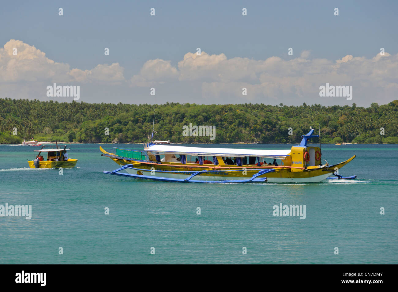 Muelle Bay, Puerto Galera, Oriental Mindoro, Philippinen, Südostasien - gelbe touristische Pendler Ausleger Boot banca Stockfoto