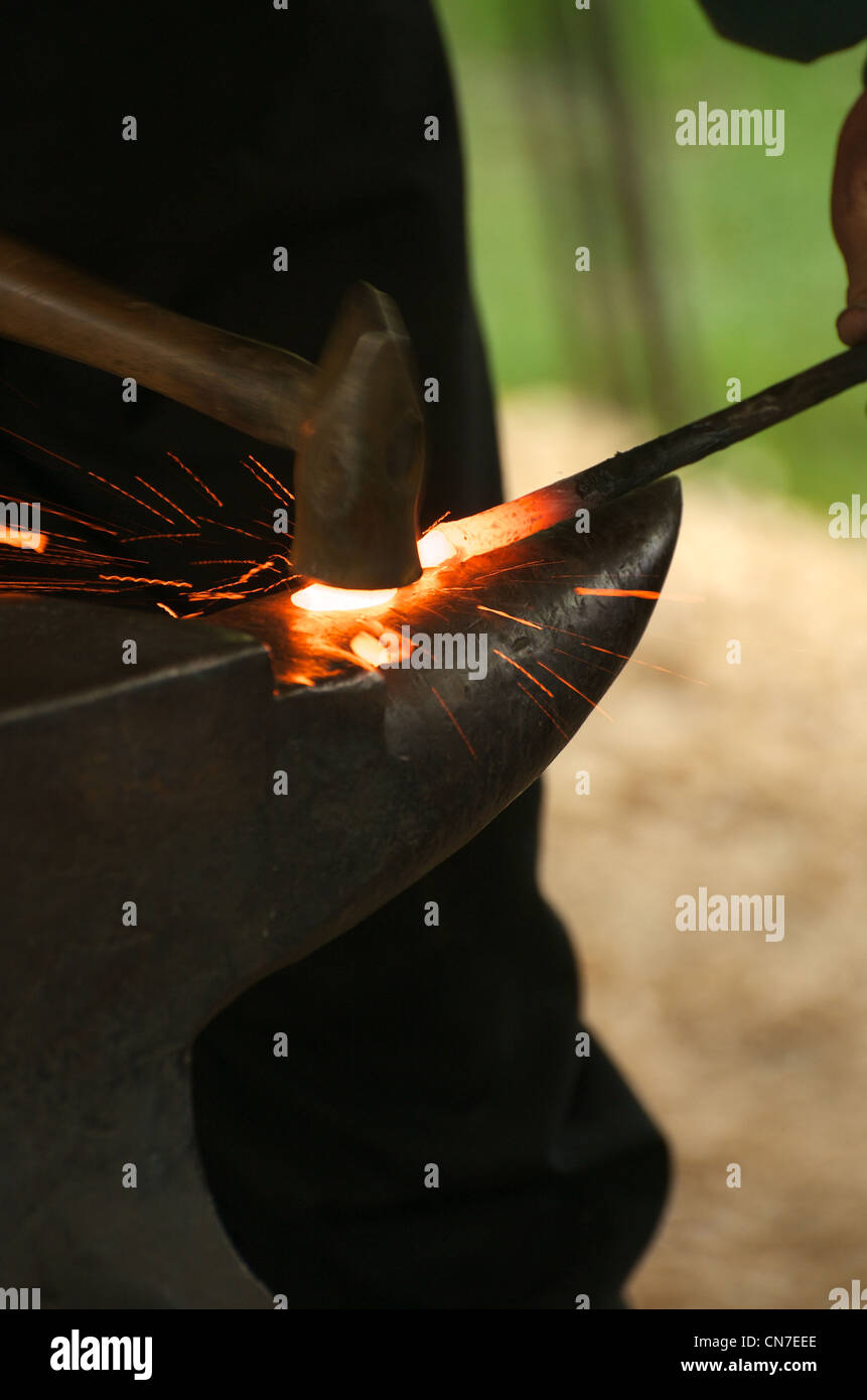 Ein Schmied arbeitet rote heiße Eisen an einem Amboss. Stockfoto