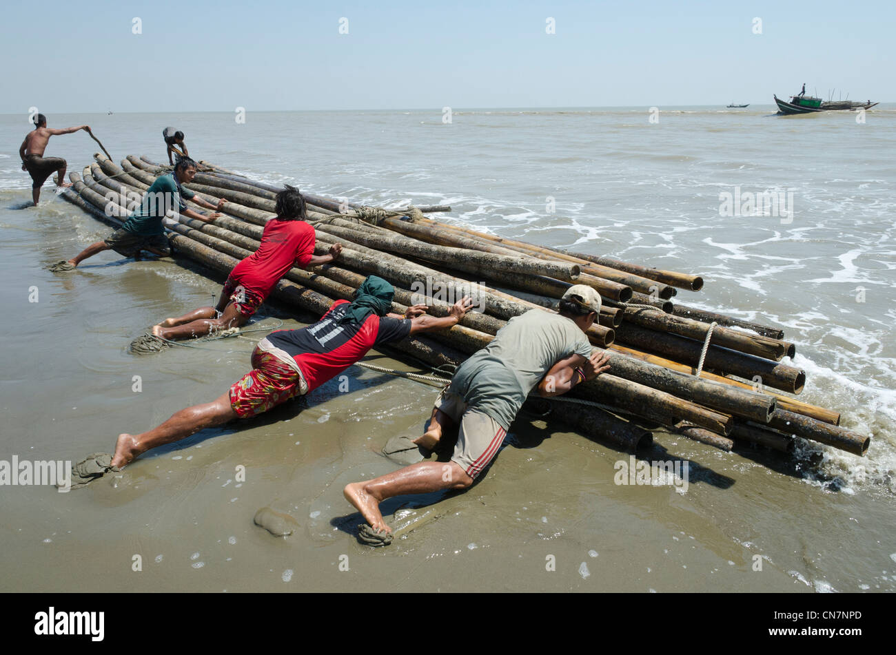 Men Umgang mit Bambus-Produkte von einem Boot im Meer aus. Irrawaddy-Delta. Myanmar. Stockfoto