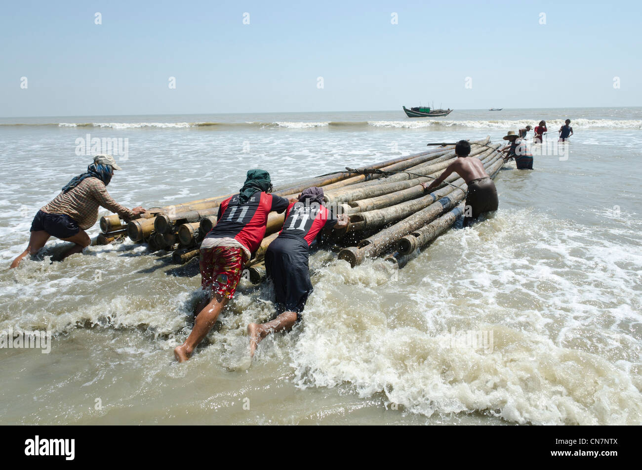 Men Umgang mit Bambus-Produkte von einem Boot im Meer aus. Irrawaddy-Delta. Myanmar. Stockfoto