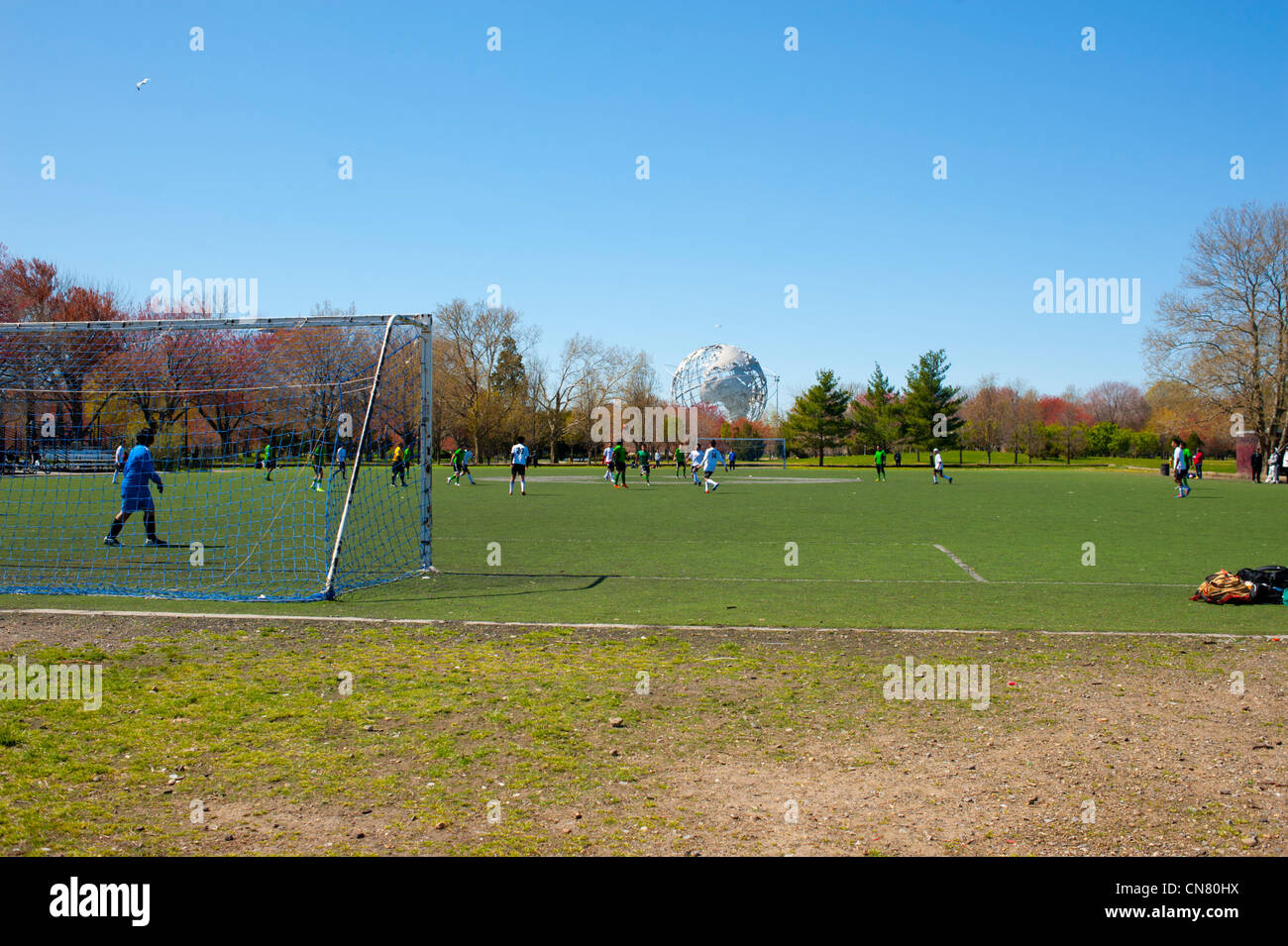 USA New York City Queens Erde Welt Unisphere Kugel in Flushing Meadows Corona Park - Kinder spielen Fußball in Bereichen Stockfoto