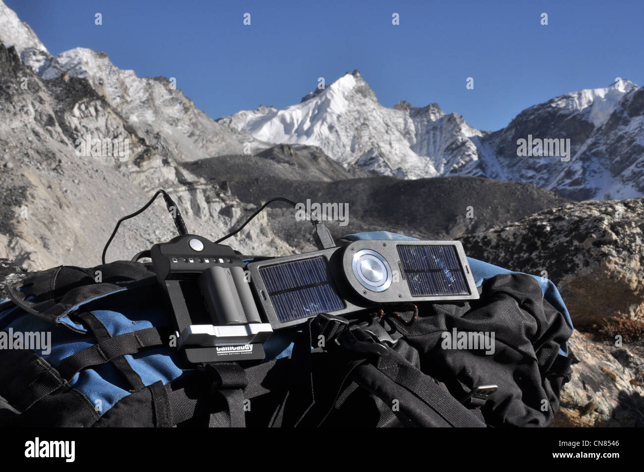 Solar-Ladegerät aufladen der Kamera im Himalaya, ruht auf einem Bergsteiger-Rucksäcke Stockfoto