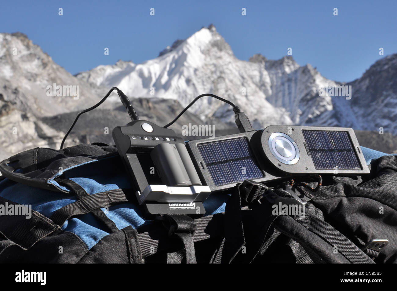 Solar-Ladegerät aufladen der Kamera im Himalaya, ruht auf einem Bergsteiger-Rucksäcke Stockfoto
